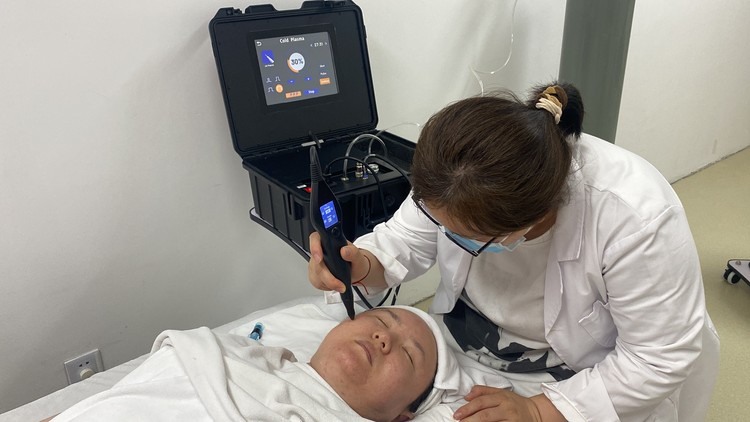 practitioner treating a client in a plasma treatment room